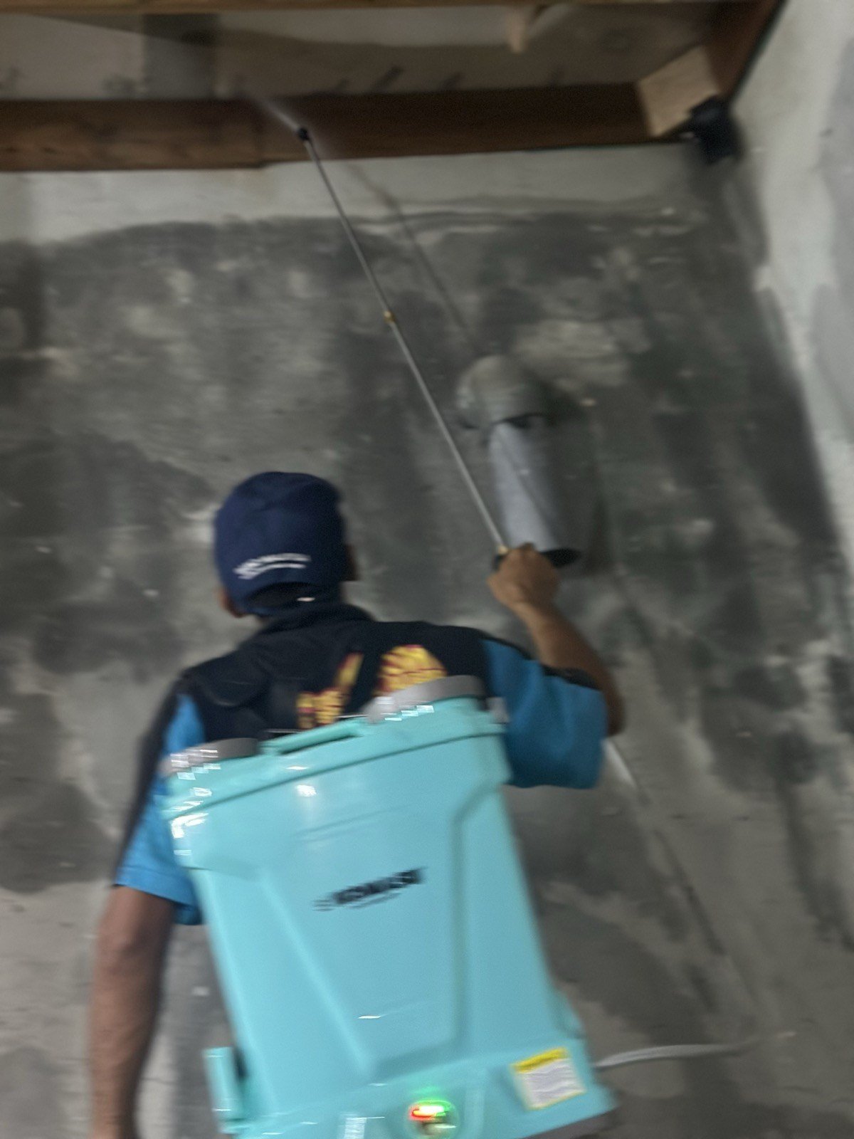 Pekerja sembur dinding dengan pam galas