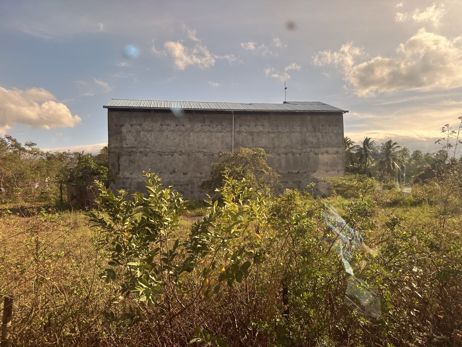 A swiftlet house standing in an open field, still without birds