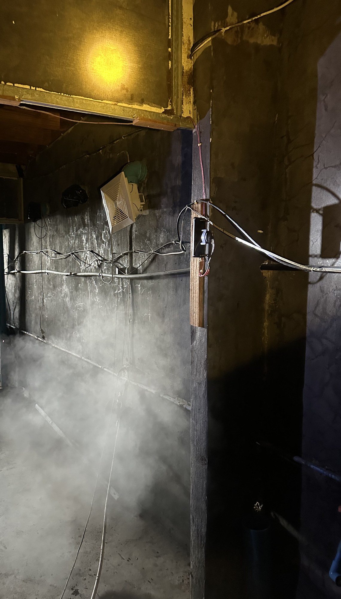 Smoke inside a swiftlet house corridor, with an exhaust fan on the wall