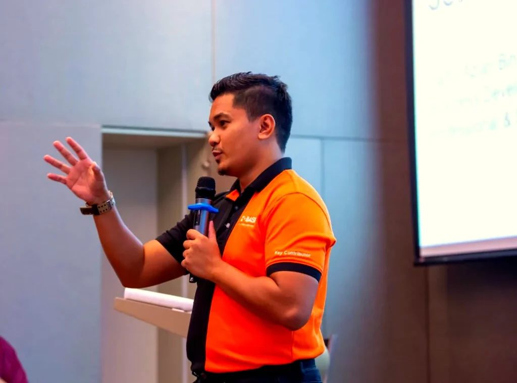 Penceramah jemputan bercakap dengan mikrofon di kursus